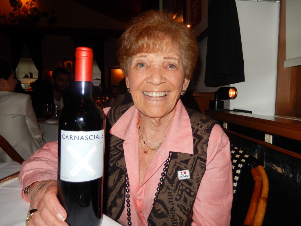 woman holding a bottle of wine and smiling