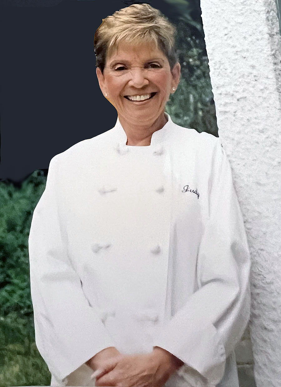 smiling red haired woman in white chef's coat
